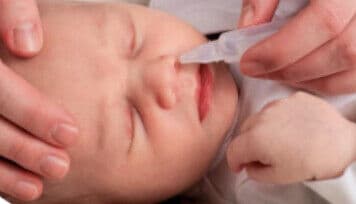 Avant 4 mois : le bébé est installé sur le côté, tenu fermement pendant le geste.