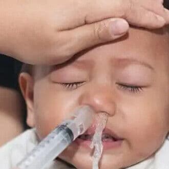 Le liquide et les sécrétions ressortent par la narine opposée, ou l'enfant éternue.